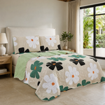 Juego de cubrecama reversible beige con flores blancas, negras y verdes con centros naranja.