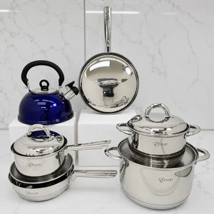 Juego de cocina Epicure by Joseph Marcus con ollas de acero inoxidable, sartén con tapa metálica y tetera azul silbante sobre fondo blanco.