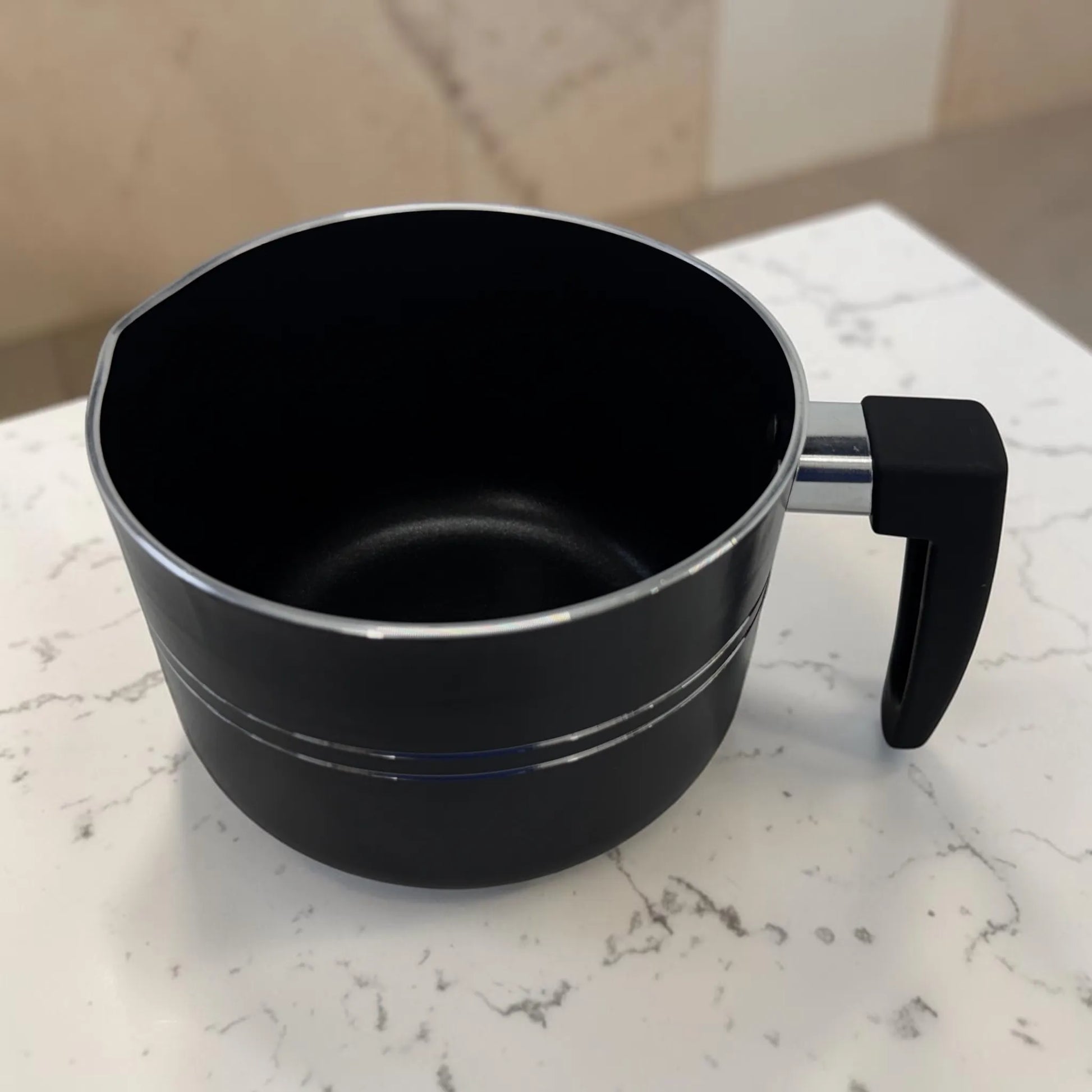 Lechero ROCA negro sin tapa con mango lateral ergonómico y acabado antiadherente exterior.