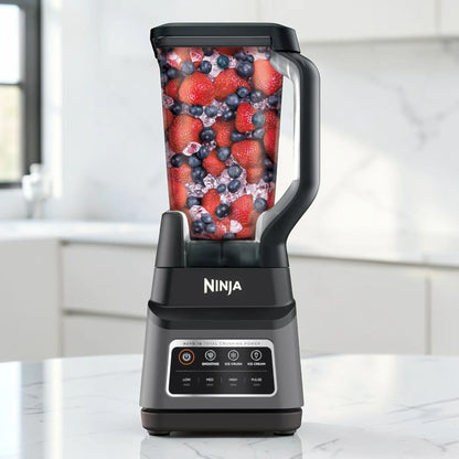 Licuadora Ninja Professional Plus con Auto-IQ BN701 en color gris oscuro y negro, vista frontal sobre encimera de cocina, con vaso transparente de 72 oz lleno de fresas, arándanos y hielo.