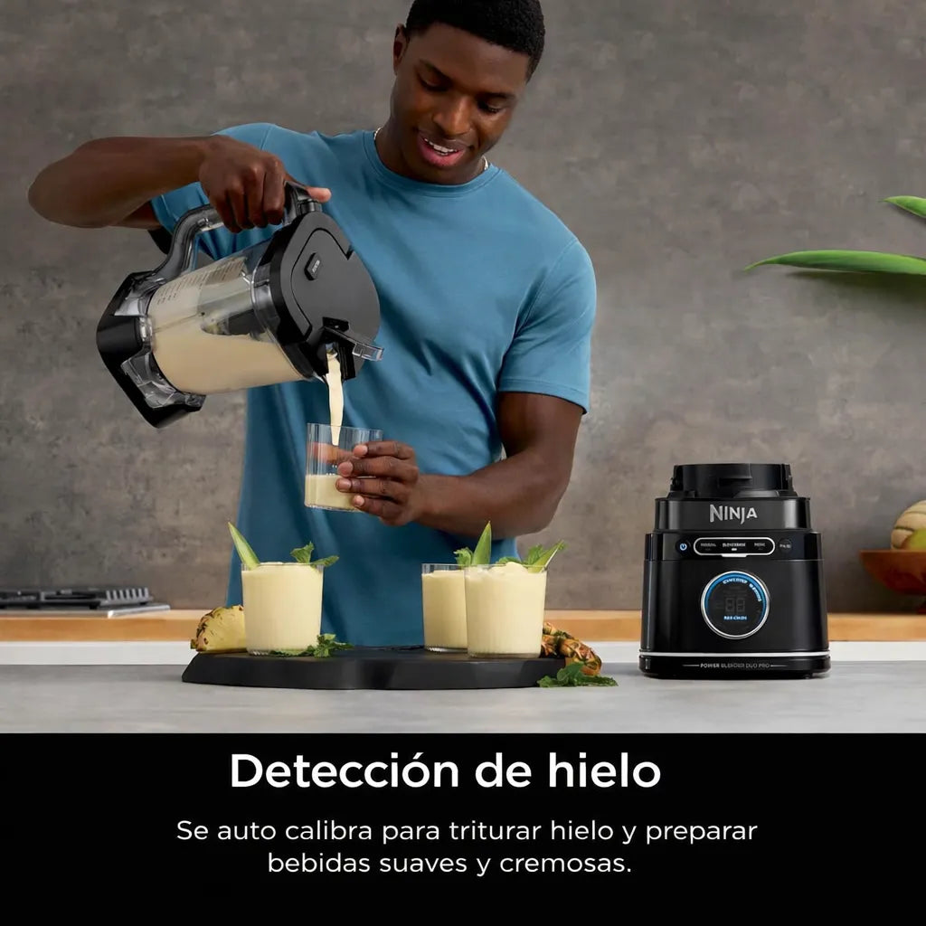 Hombre sirviendo bebida cremosa preparada con la licuadora Ninja TB301 negra con tecnología BlendSense y detección de hielo, usando la jarra grande sobre encimera.