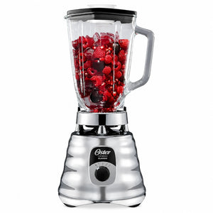 Licuadora clásica Oster cromada BLST4655 con vaso de vidrio de 1.25 litros lleno de frutos rojos, vista frontal sobre fondo blanco.