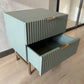 Mesa auxiliar STUDIO-1061 verde oliva con cajón inferior abierto, diseño moderno acanalado y patas metálicas doradas.