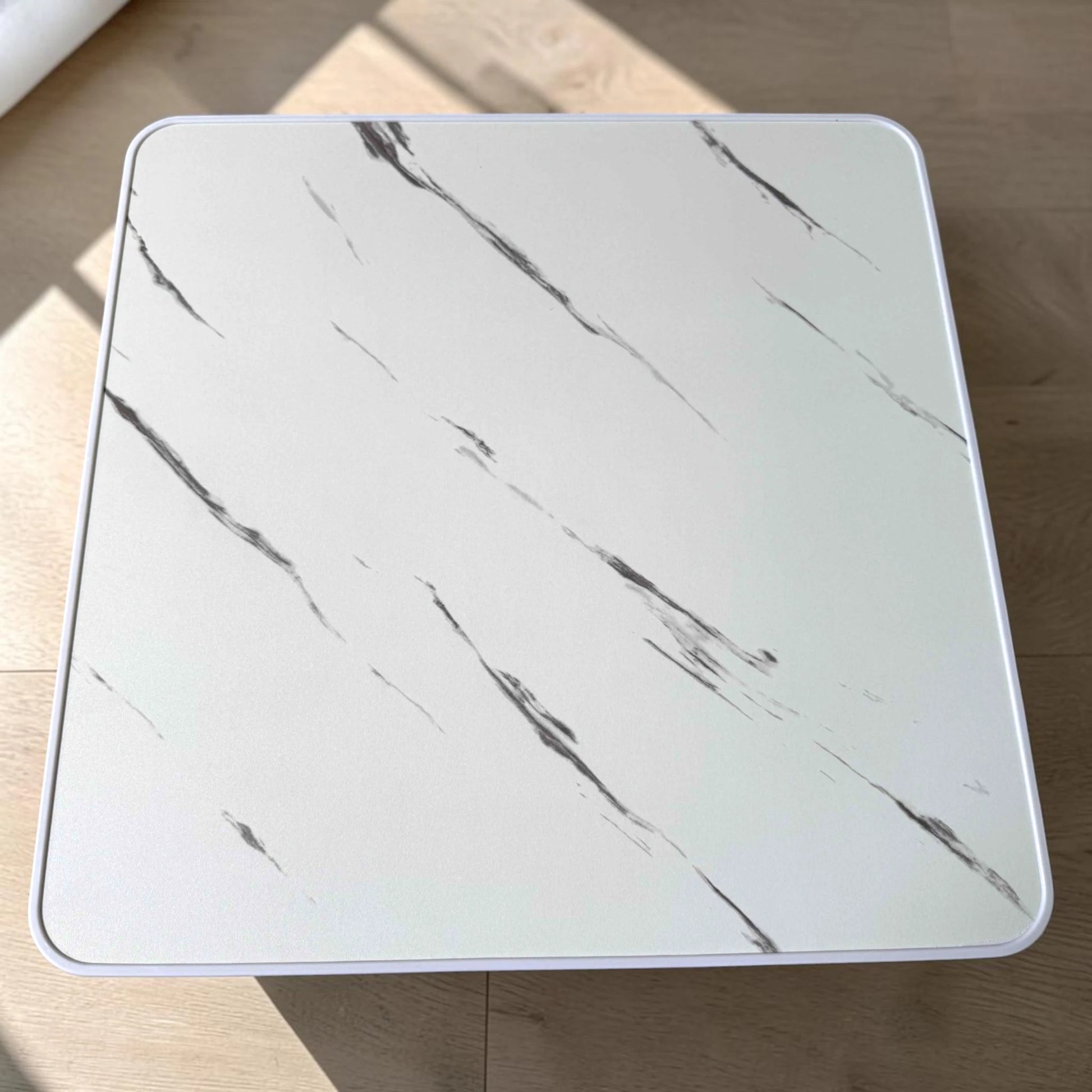 Vista superior de mesa plegable multiusos Ambienta Home Decor color blanco tipo mármol de 60x60 cm con vetas grises y borde blanco, SKU 41346.