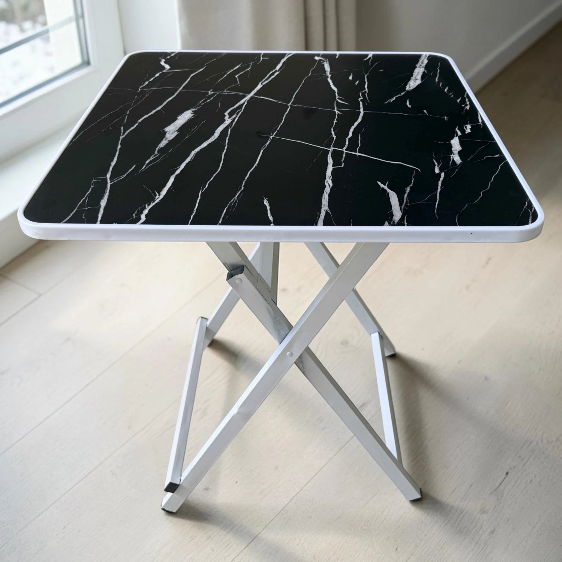 Mesa plegable multiusos negra tipo mármol Ambienta Home Decor con patas blancas y superficie cuadrada de 60x60 cm, altura 72 cm, vista frontal completa, SKU 41345.