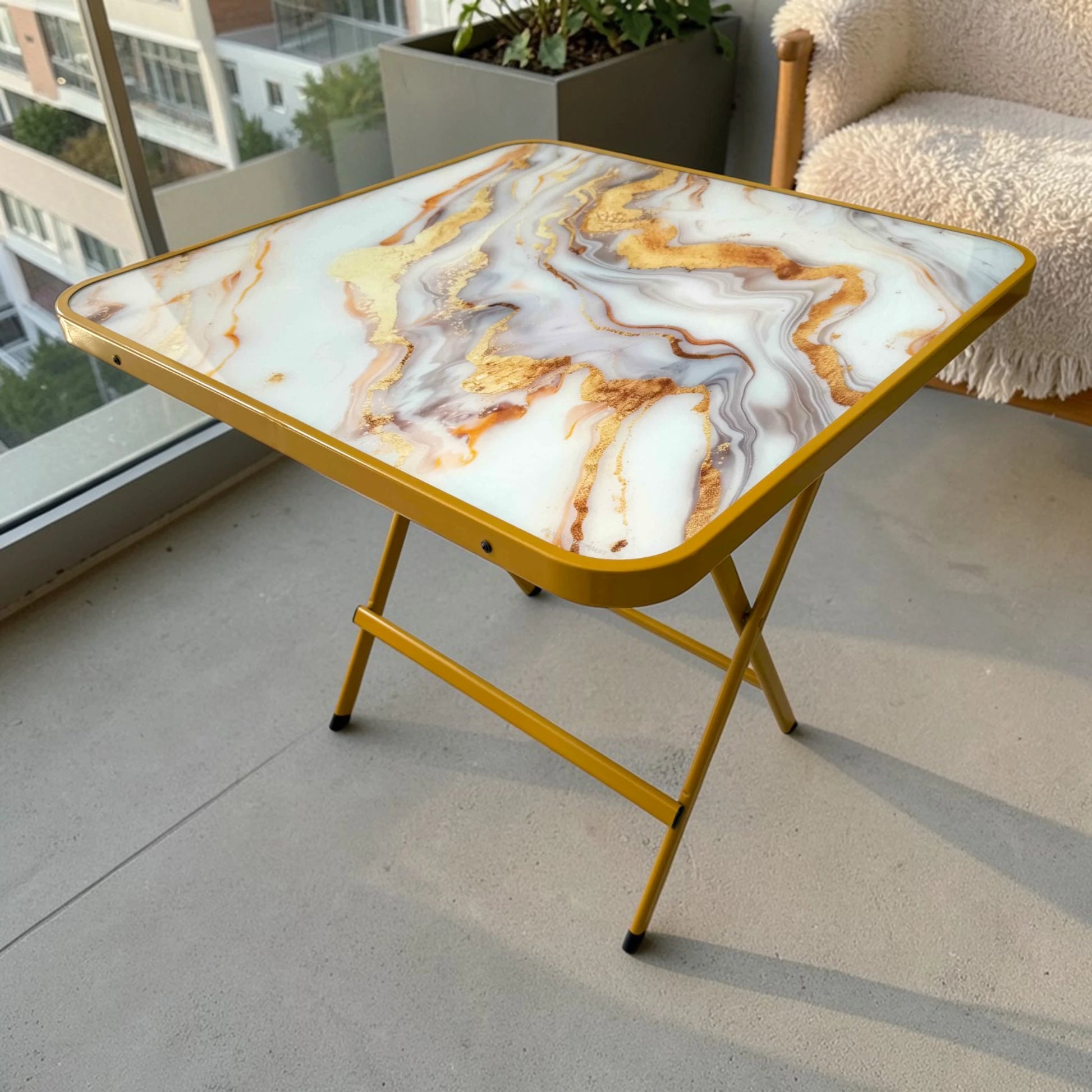 Mesa plegable multiusos cuadrada de 80x80 cm con acabado tipo mármol y estructura dorada, vista en perspectiva superior.