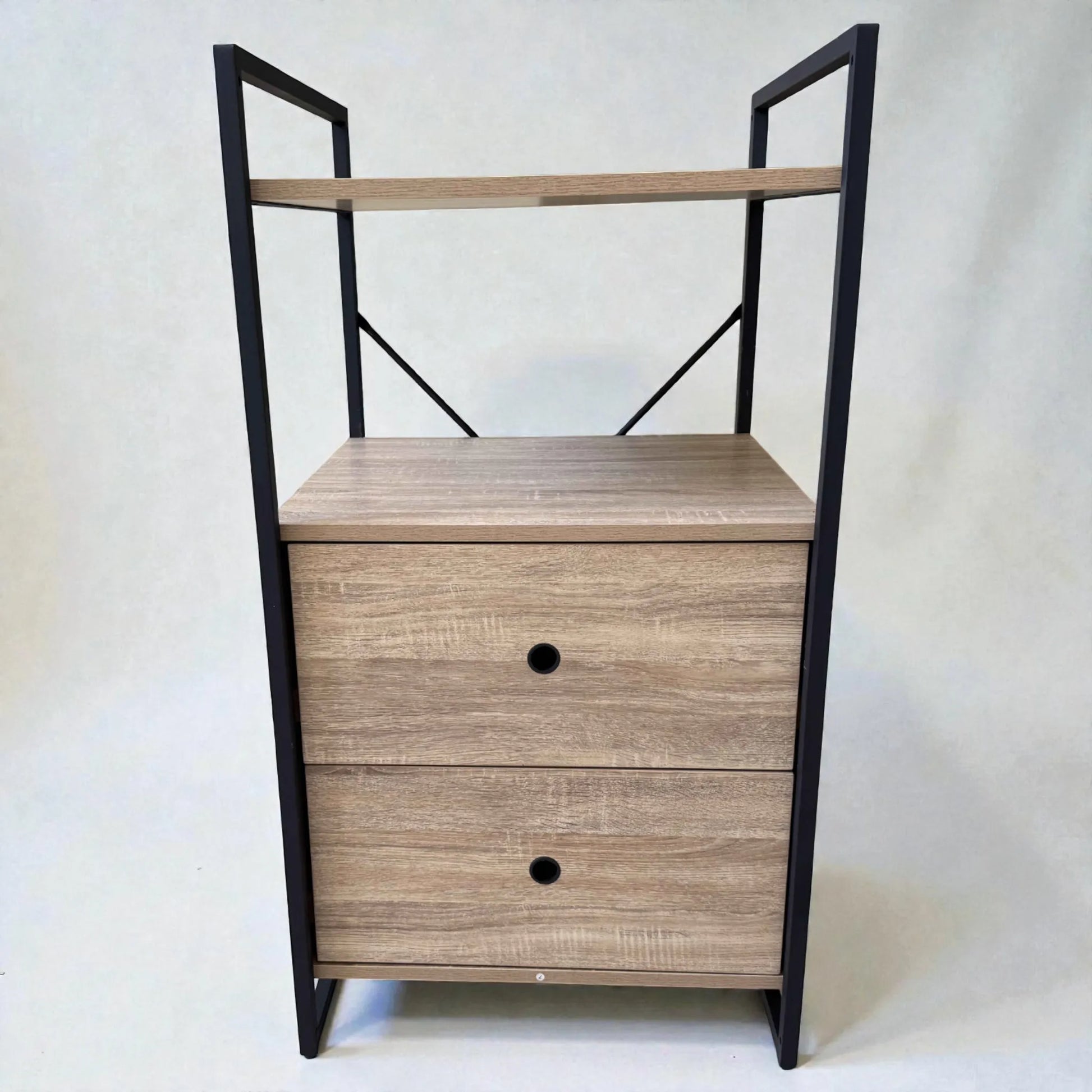 Vista frontal del mueble auxiliar Flexi Storage Studio de 60 x 58 x 113 cm con dos gavetas de melamina color roble, repisa superior y estructura rectangular de metal negro.