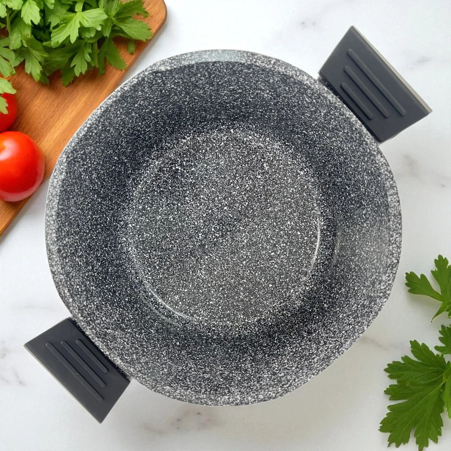 Olla antiadherente de 24 cm marca NSFE, color gris granito, vista superior con asas negras, sobre fondo de cocina con vegetales frescos.