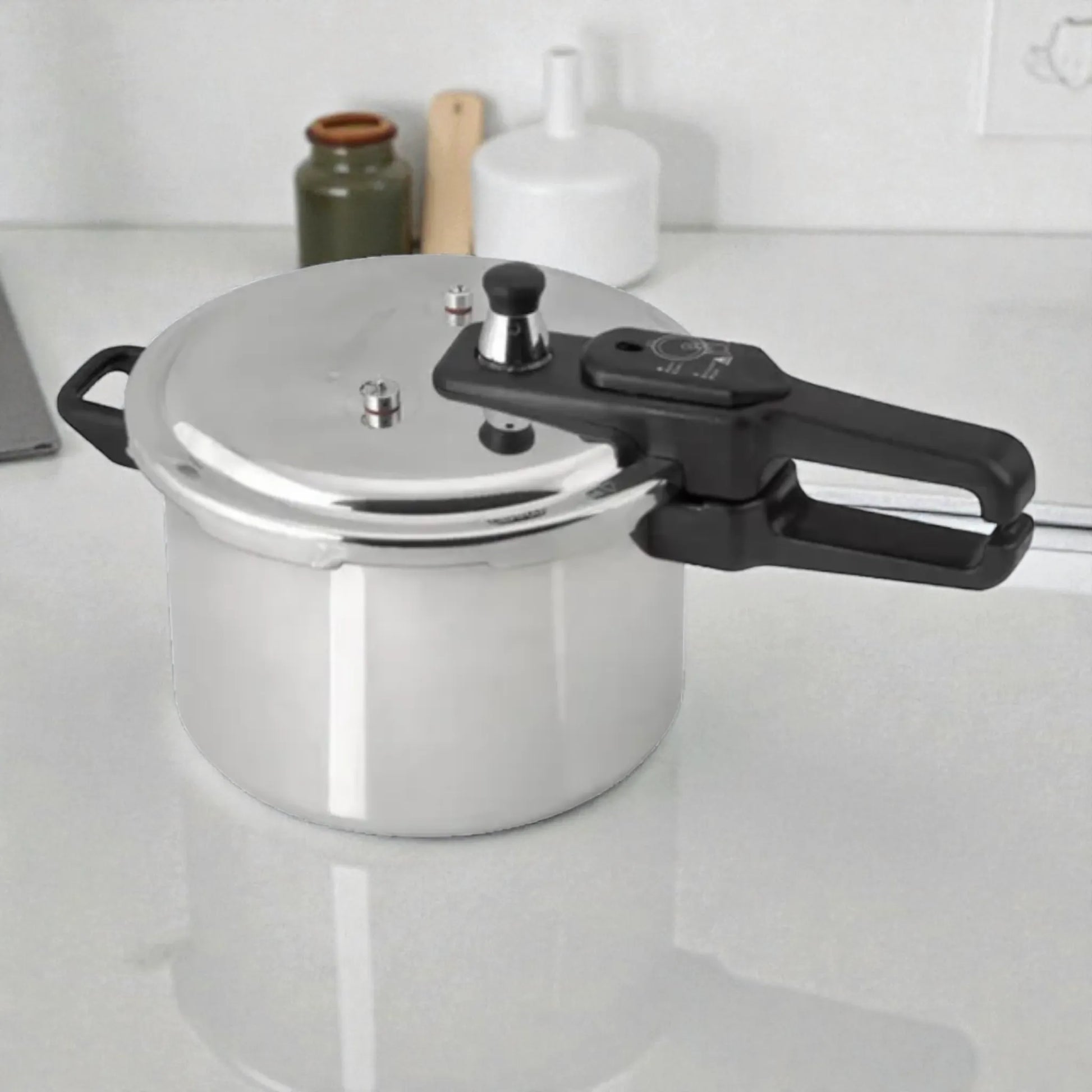 Olla de presión Black+Decker PC700 de 7 litros en aluminio plateado, vista general 3/4 sobre encimera, con manija larga negra y tapa con válvulas de seguridad.