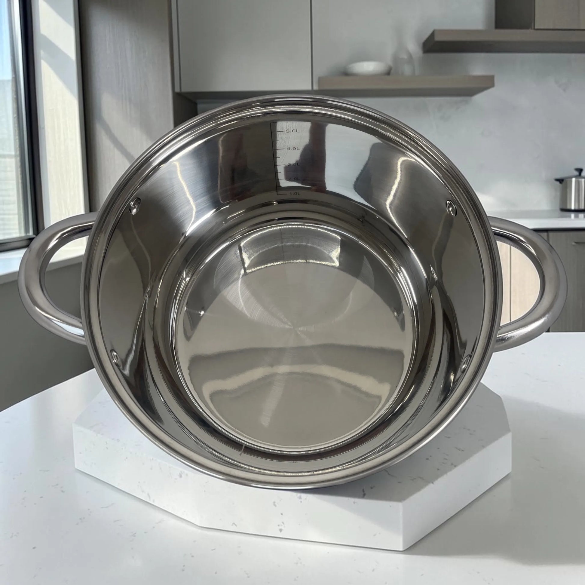 Interior de olla Epicure de acero inoxidable de 5 litros con marcas medidoras internas, asas laterales y acabado brillante.