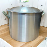 Olla de aluminio industrial grande con tapa colocada en encimera de cocina