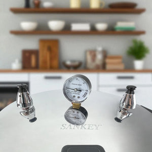 Detalle del manómetro y válvulas de seguridad de la olla de presión Sankey de 22 litros en aluminio, sobre fondo de cocina.