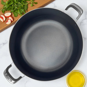 Vista superior del interior de olla antiadherente ROCA con revestimiento metálico plateado, exterior de granito negro y asas Bake-lite, tamaño 38x16 cm.