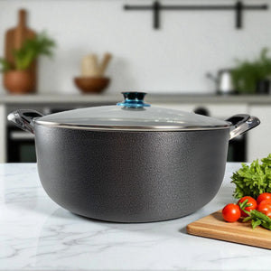 Olla antiadherente ROCA con exterior de granito color negro, tapa de vidrio templado y asas Bake-lite, tamaño 38x16 cm, vista frontal sobre mesa de cocina.