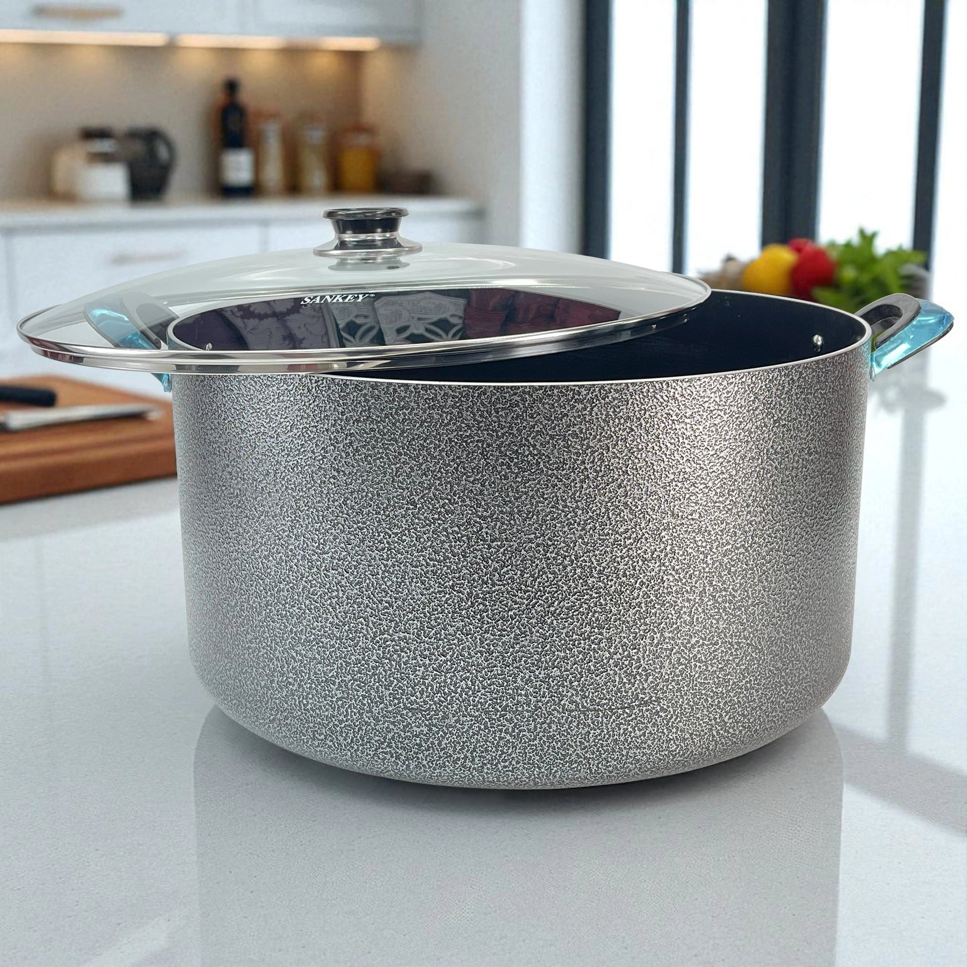 Olla Sankey de cerámica gris de 44 cm con tapa de vidrio y asas azul brillante, lista para cocinar en cocina bien iluminada