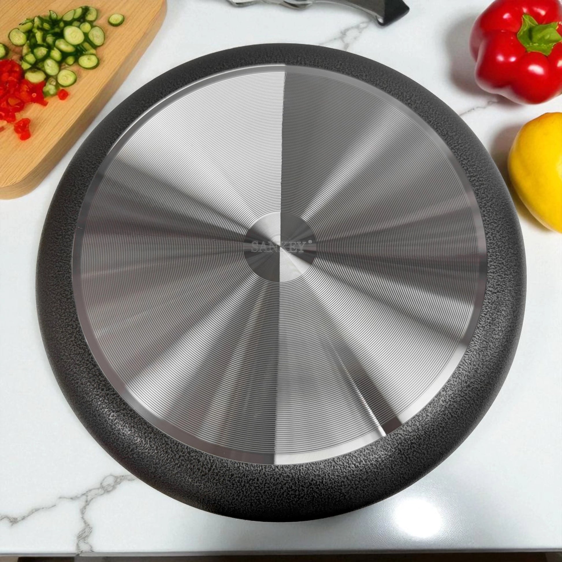 Detalle inferior de olla cerámica Sankey gris 36 cm, con superficie de inducción en acero.