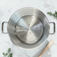 Olla vaporera de aluminio Lotus con bandeja perforada colocada en el interior para cocinar alimentos al vapor.