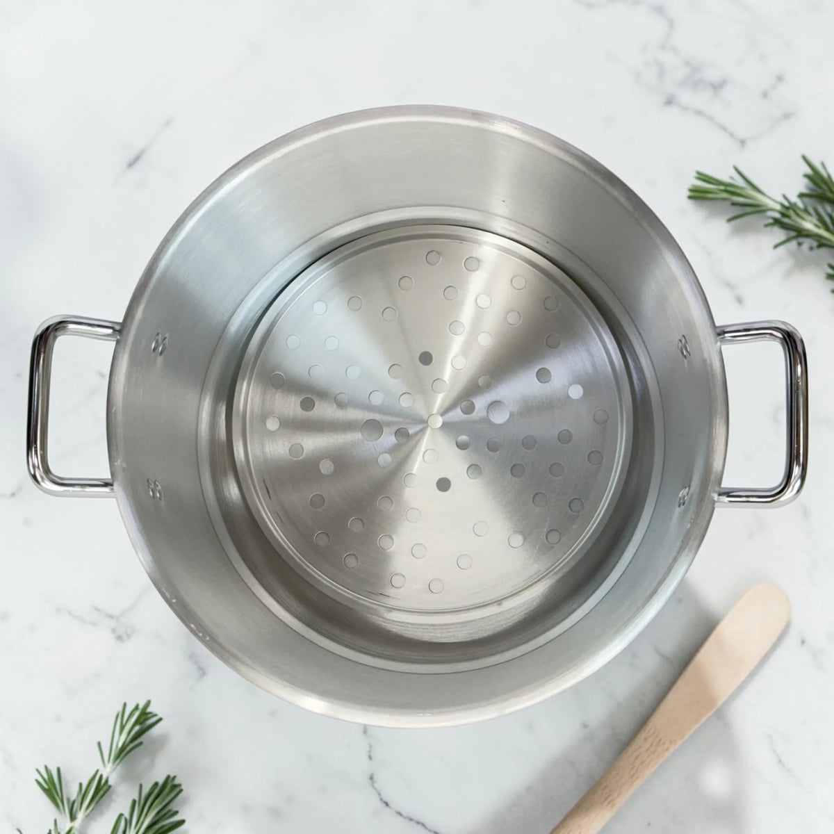 Olla vaporera de aluminio Lotus con bandeja perforada colocada en el interior para cocinar alimentos al vapor.