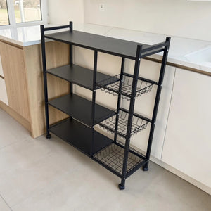 Vista en perspectiva del organizador de cocina metálico Ambienta Home Decor color negro con cuatro repisas, tres canastas laterales y ruedas para almacenamiento y organización.