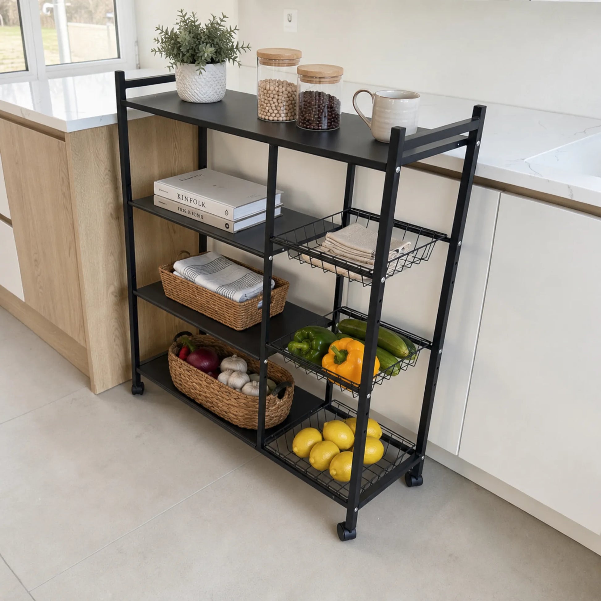 Organizador de cocina Ambienta Home Decor color negro con cuatro repisas, tres canastas y ruedas organizando frutas, verduras, libros, recipientes y accesorios en una cocina moderna.