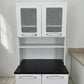 Vista frontal cercana del organizador de cocina 2x1 Bertolini blanco con tablero negro, puertas superiores decoradas y compartimento central abierto.