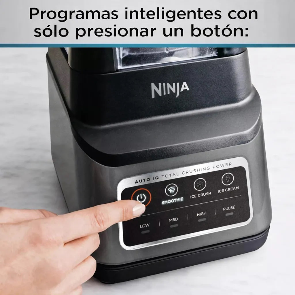 Panel de control de la licuadora Ninja Professional Plus BN701 con programas Auto-IQ, botones para smoothie, ice crush e ice cream, y mano presionando el botón de encendido.