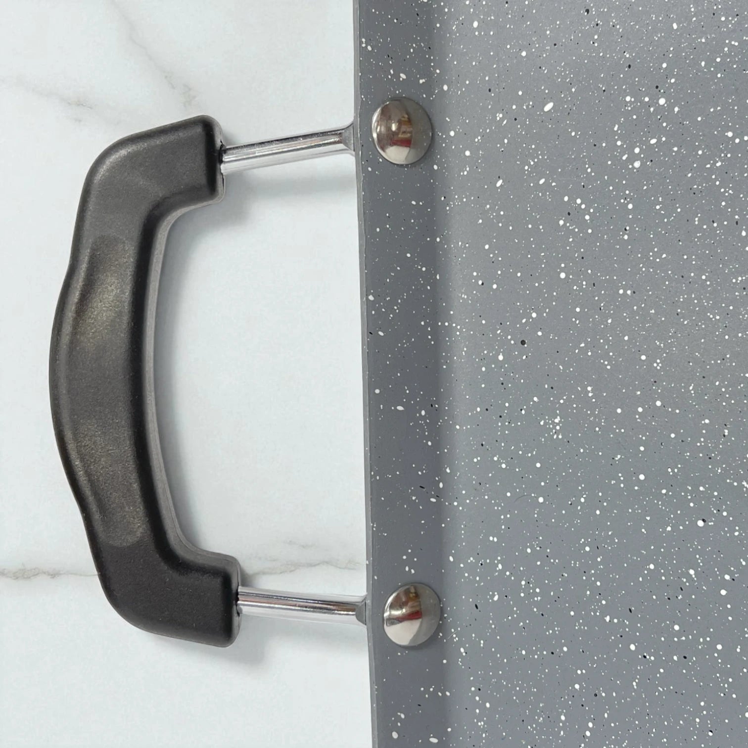 Detalle de la plancha Estrella Gourmet de doble quemador mostrando mango ergonómico negro y superficie gris marmolizada antiadherente.