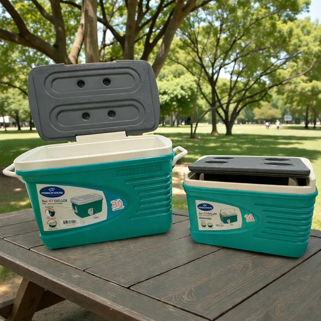 Hielera Princeware New Icy Chiller 30L con tapa abierta mostrando interior, junto a hielera 14L al lado sobre mesa de picnic en parque; set 3409-C1PB color turquesa con detalles blanco/gris.