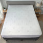 Vista cenital de un protector de colchón impermeable de fibra de bambú, color blanco, cubriendo completamente una cama grande con falda lateral ajustada.
