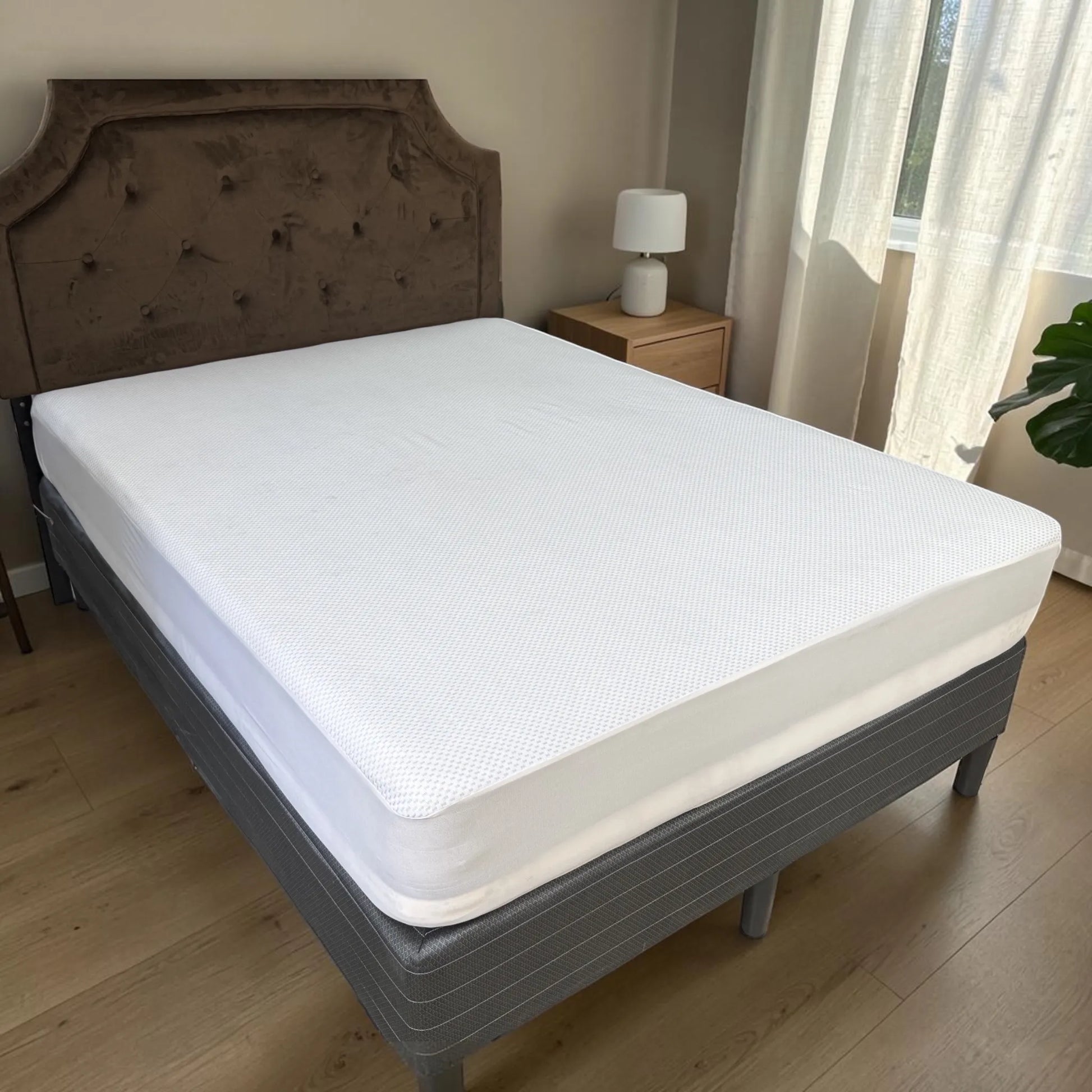 Protector de colchón impermeable Cooling color blanco instalado y ajustado sobre una cama tamaño Full en dormitorio moderno con luz natural.