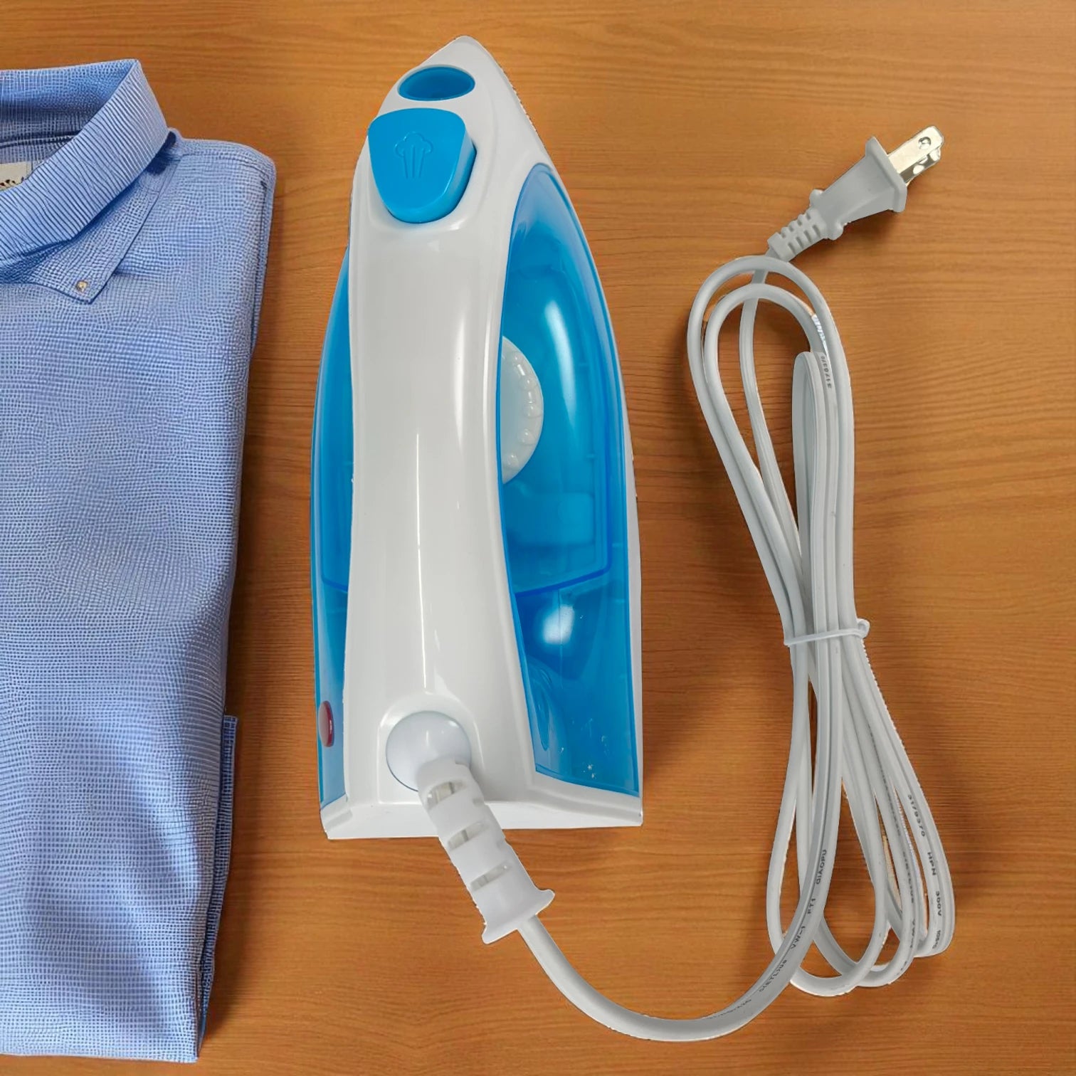 Plancha a vapor Sankey PV-108 azul vista desde arriba, con cable blanco enrollado y camisa doblada al lado.
