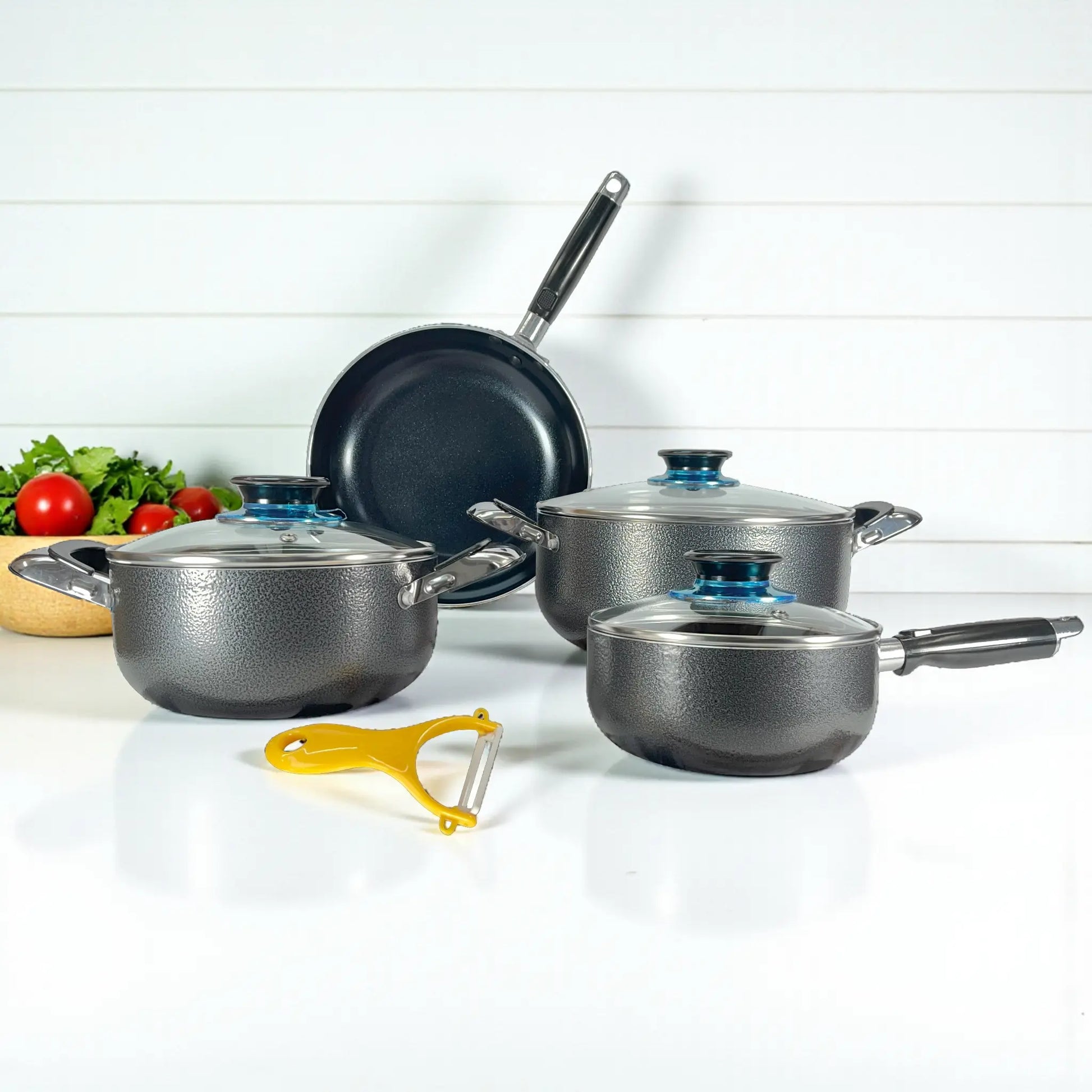 Vista frontal del set Sankey W-757 sobre fondo blanco: sartén 24 cm al fondo, ollas 24 y 18 cm, cacerola 16 cm al frente; perillas azules en tapas de vidrio.