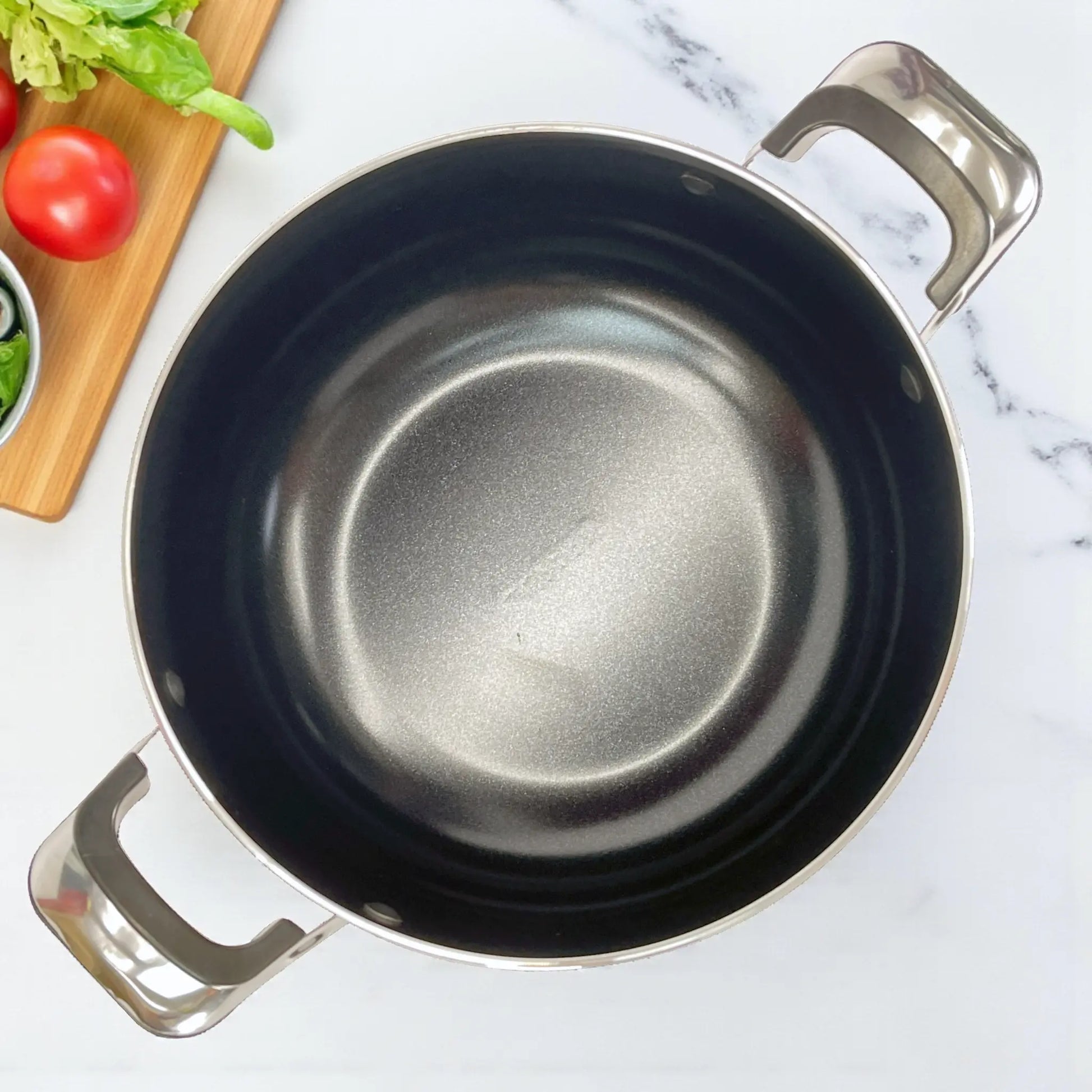 Vista superior del interior cerámico antiadherente de la olla 24 cm del juego Sankey W-757, bordes redondeados y acabado negro.