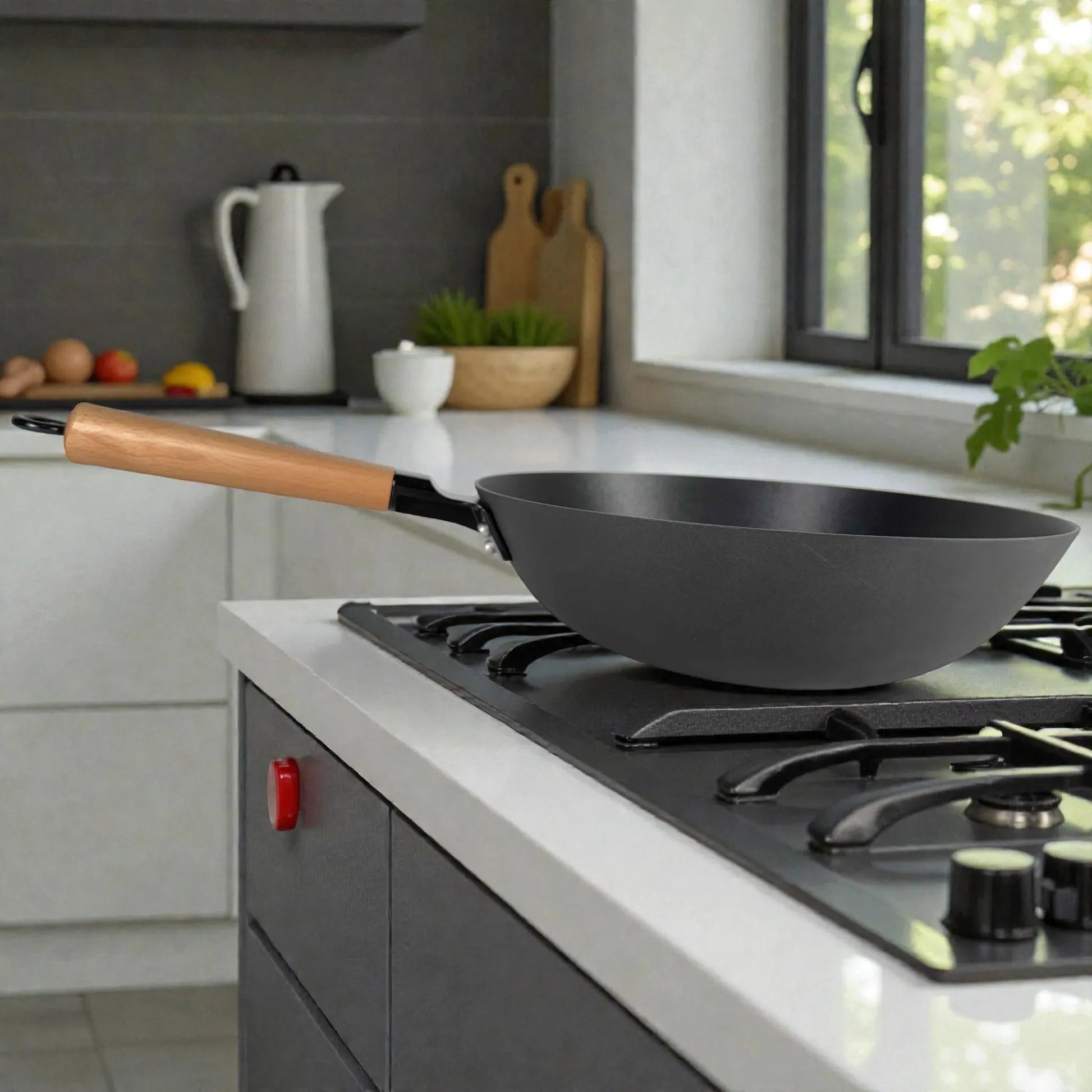 Wok Sankey negro de hierro fundido 30 cm (12”) en estufa de gas, vista lateral en cocina luminosa con ventana y encimeras claras.