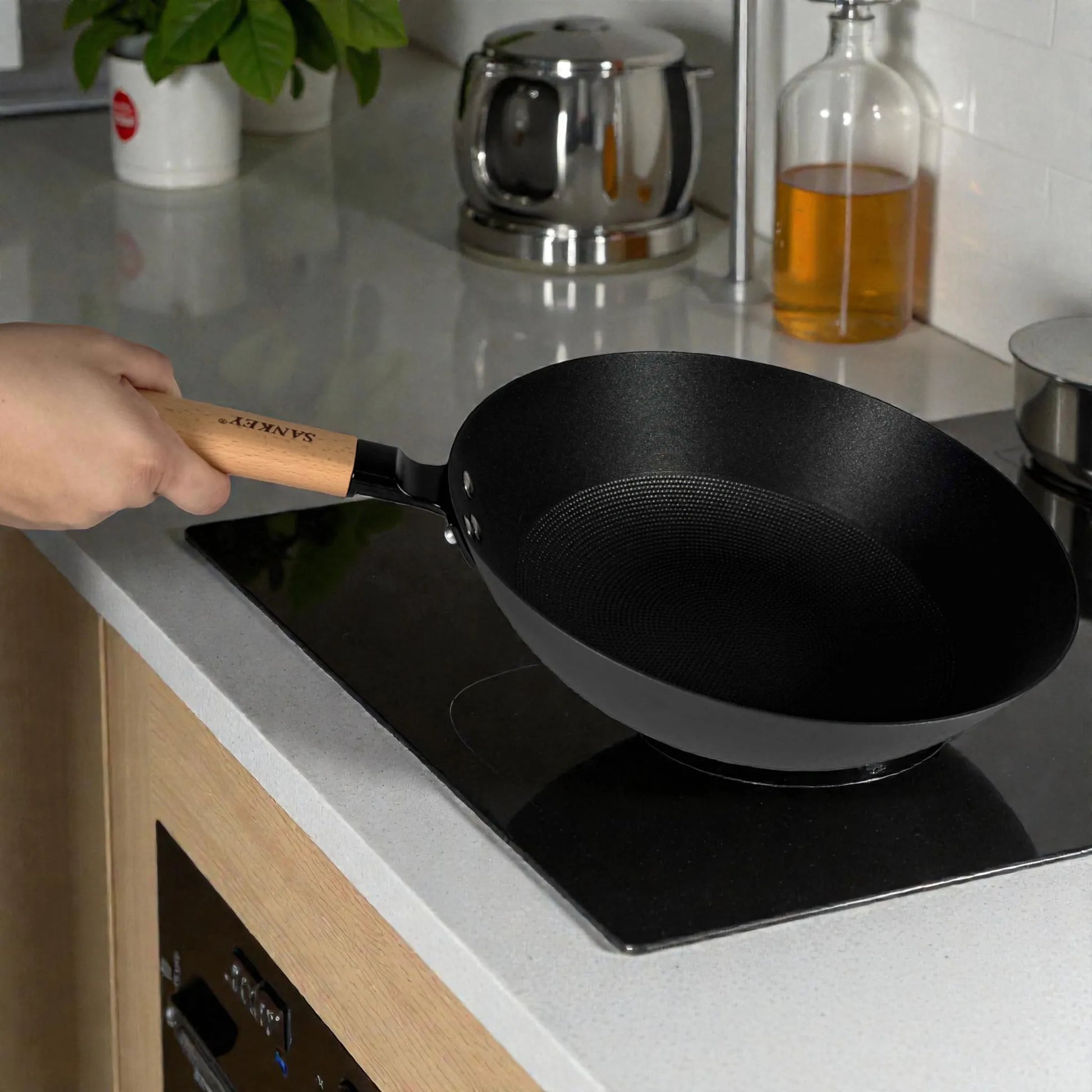 Wok Sankey de hierro fundido negro 30 cm (12”) con mango de madera, colocado en estufa de inducción/vitrocerámica mostrando interior tipo panal.