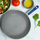 Vista superior del interior antiadherente marmolizado gris de un sartén Estrella Gourmet 30 cm con mango azul.