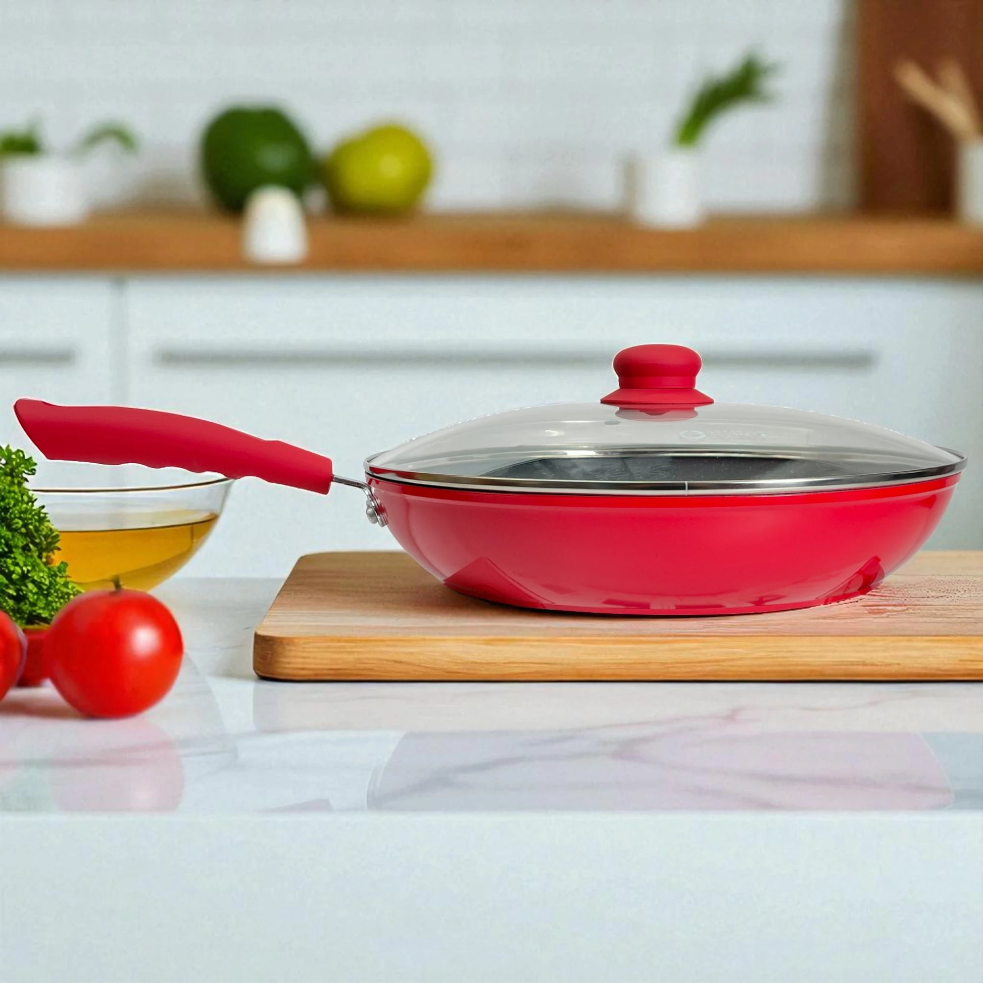 Sartén Estrella Gourmet rojo con recubrimiento marmolizado y tapa de vidrio, mango de baquelita, vista lateral sobre tabla de cocina.