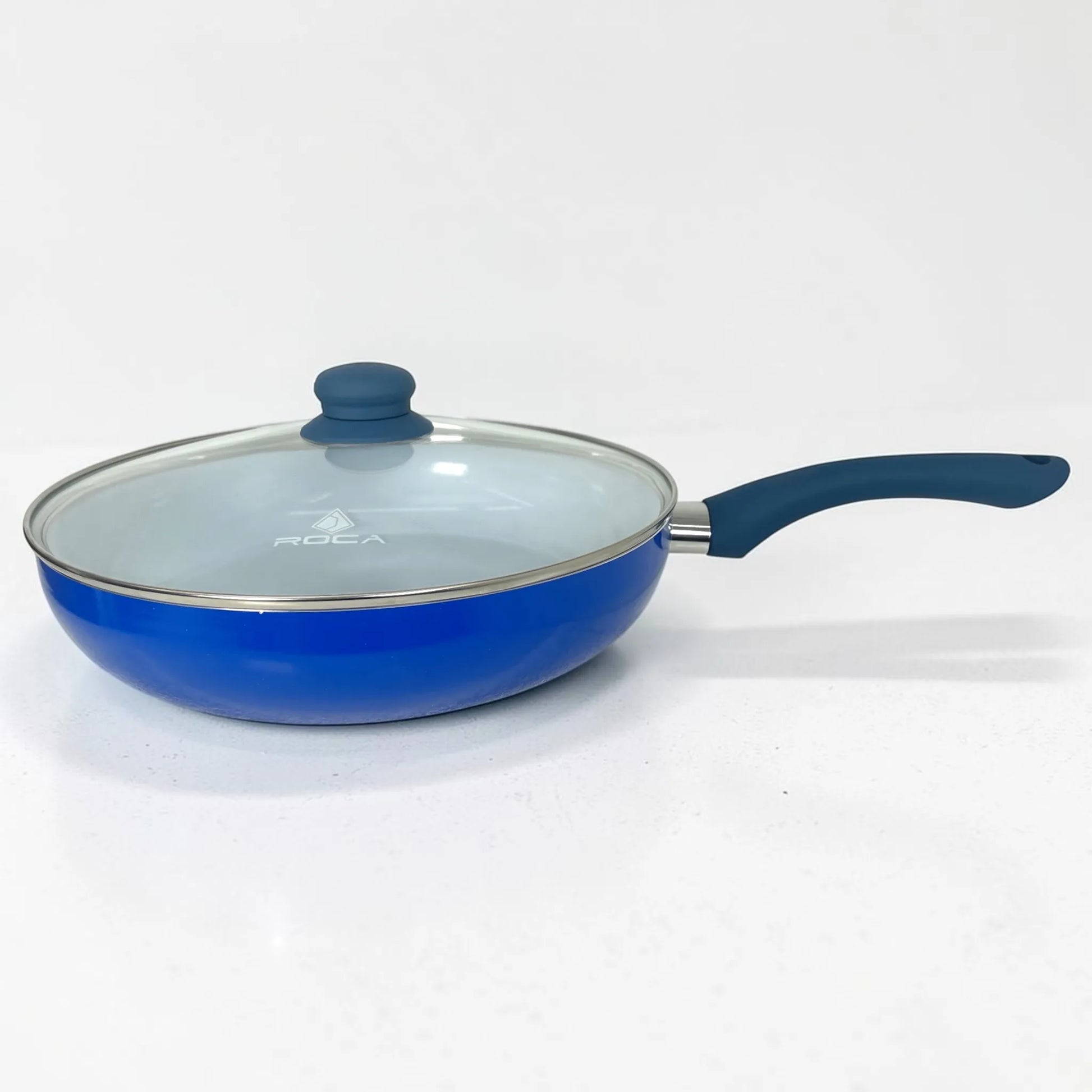 Sartén ROCA azul con recubrimiento cerámico blanco, tapa de vidrio y mango ergonómico visto de lado.