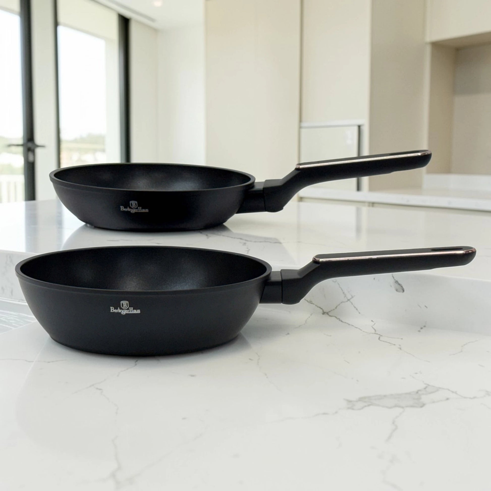 Sartén y sartén honda Berlinger Haus BH-8362 Black Rose Collection en color negro con mangos largos ergonómicos sobre encimera blanca.