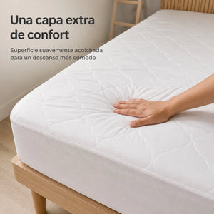 Detalle del protector de colchón Scarlett Classics blanco con superficie acolchada siendo presionada para mostrar su suavidad y confort.