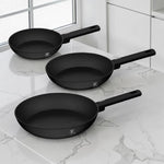 Set de 3 sartenes Berlinger Haus BH-8195A negro mate de 20, 24 y 28 cm sobre cocina moderna con superficie de mármol.
