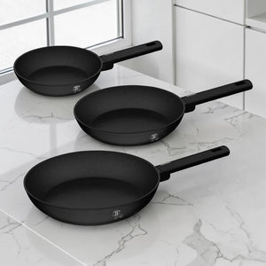 Set de 3 sartenes Berlinger Haus BH-8195A negro mate de 20, 24 y 28 cm sobre cocina moderna con superficie de mármol.