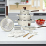 Set de cocina de 16 piezas marca NSFE modelo Athena en color blanco crema, con ollas, sartenes, tapas de vidrio templado, guantes, espátula, cucharón y esponjas, presentado sobre mesa en cocina moderna.