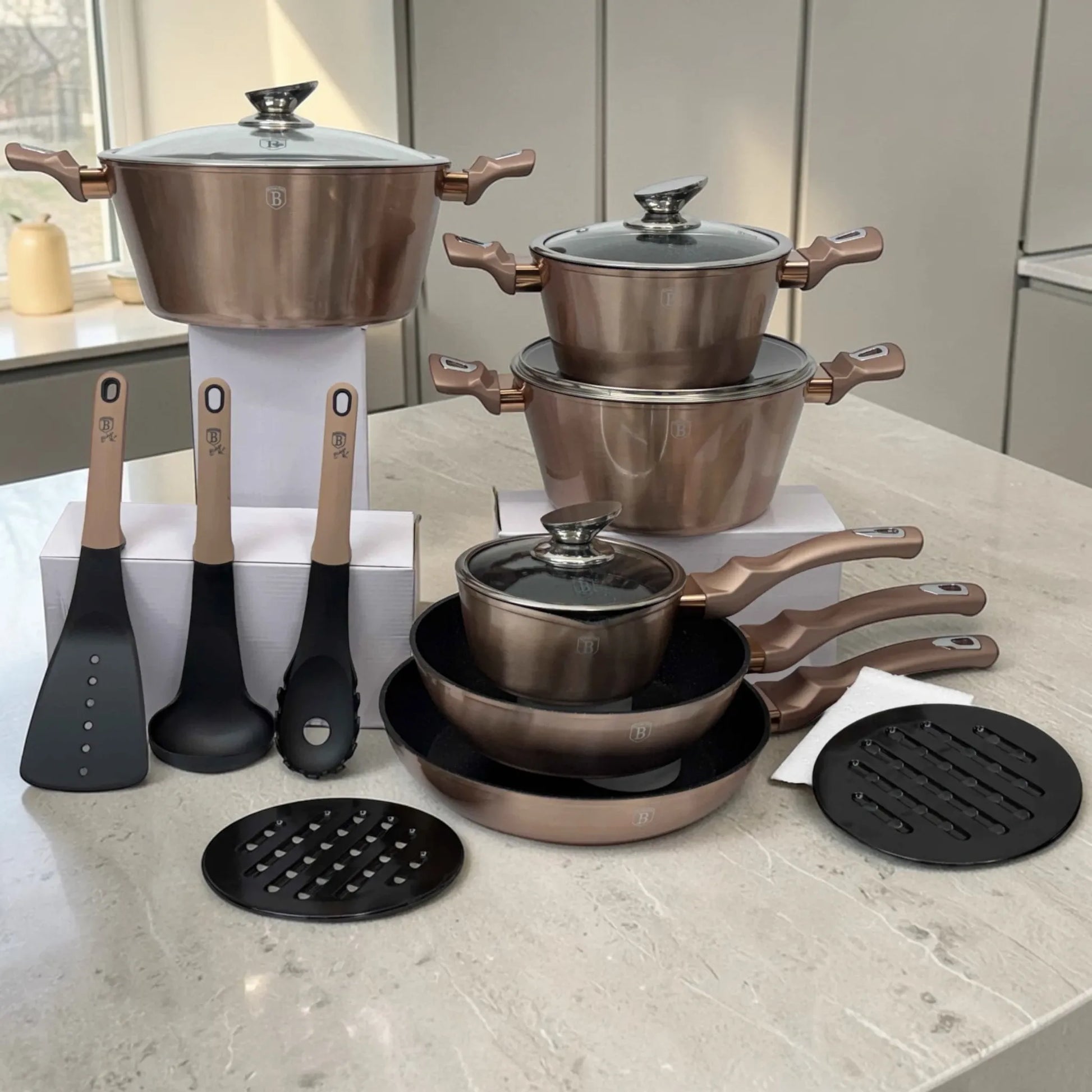 Set de cocina Berlinger Haus Rosegold BH-1224N con ollas de 28, 24 y 20 cm, sartén, sartén profunda, olla con mango, utensilios y protectores, organizado sobre encimera.