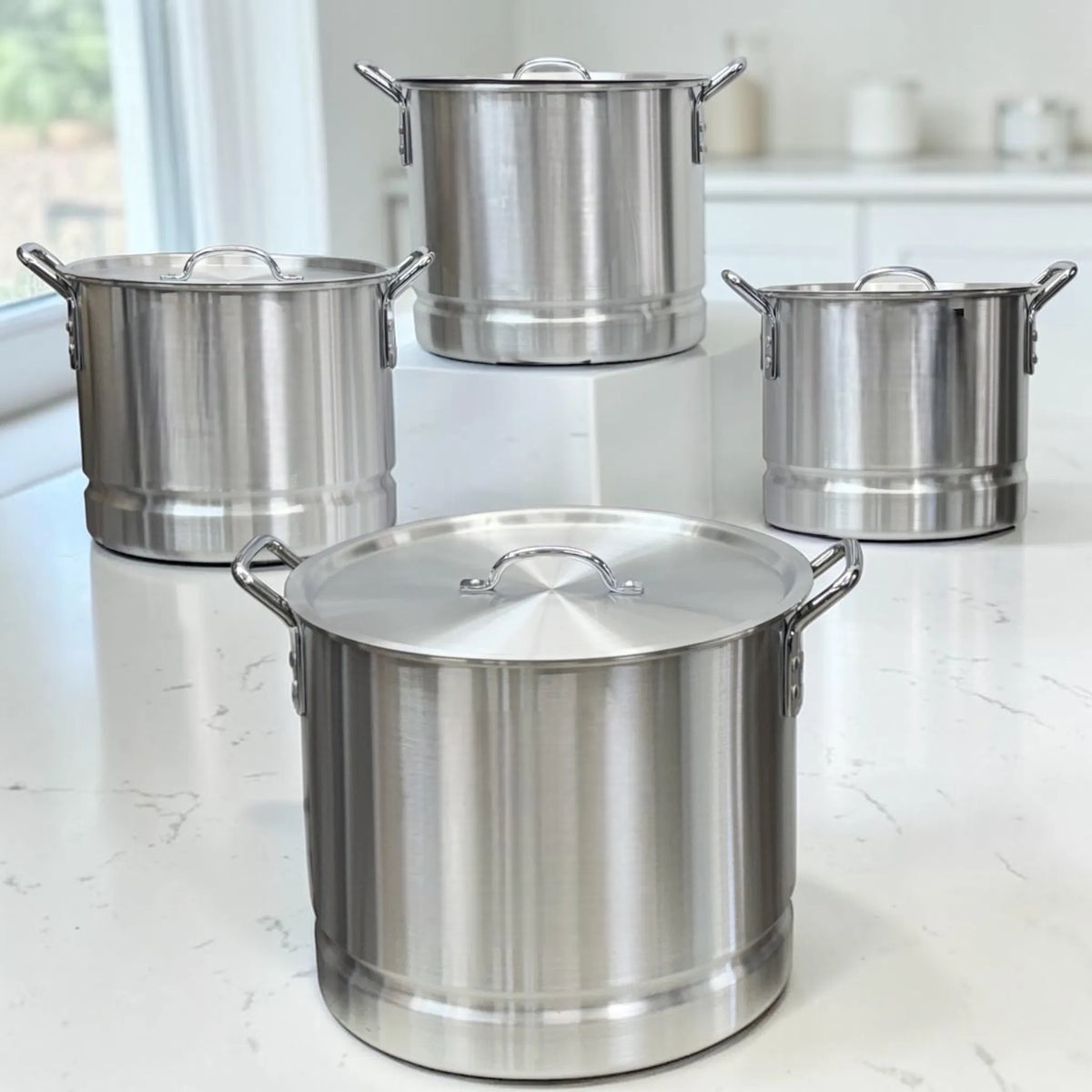 Set completo de ollas de aluminio Lotus color plateado con tapas, tamaños 20QT, 24QT, 32QT y 40QT.