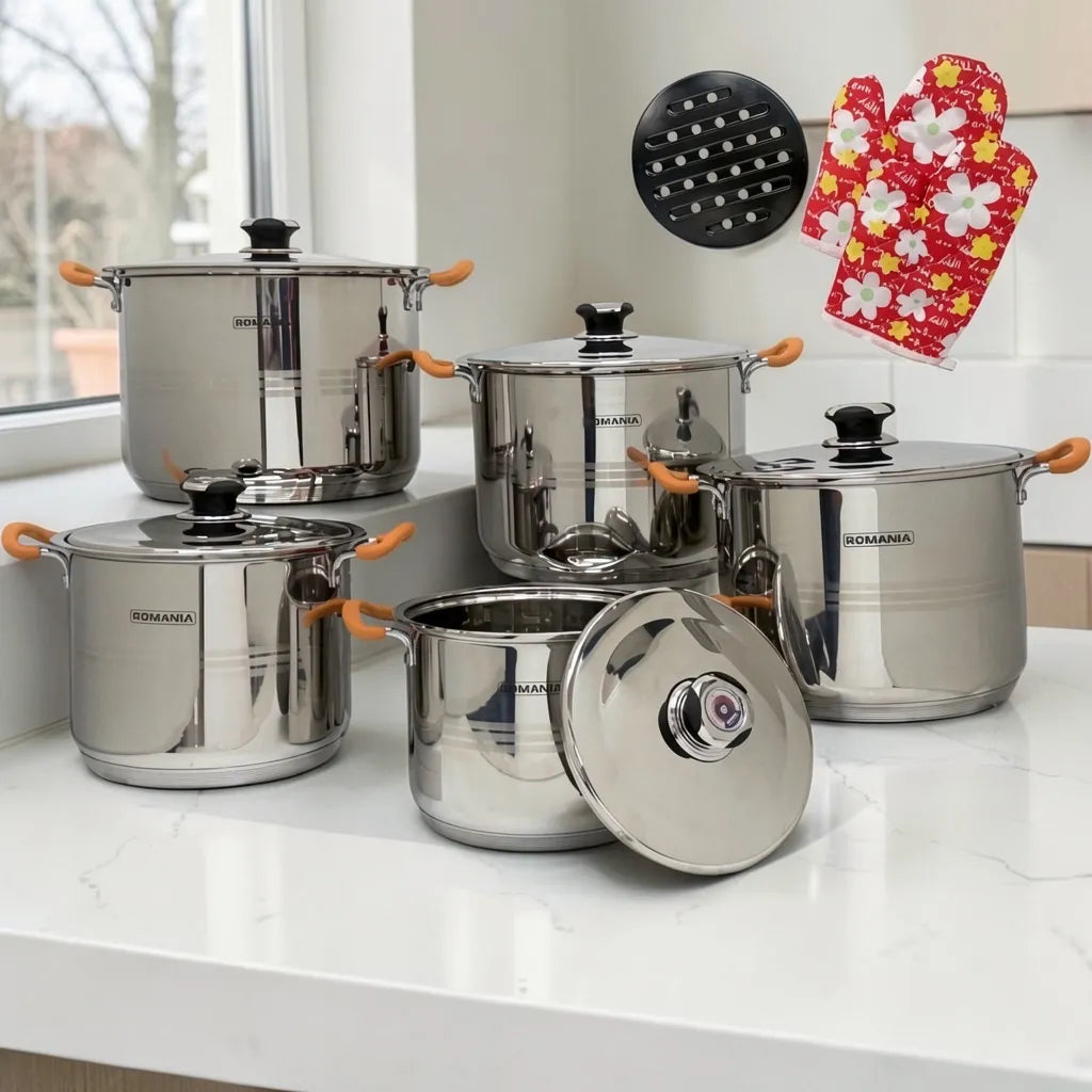 Set de ollas Romania Estilo Alemania de 10 piezas en acero inoxidable con mangos naranjas sobre encimera blanca, acompañado de guantes térmicos rojos y base metálica negra.