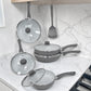 Set de sartenes ROCA color gris apilados con tapas de vidrio, mangos ergonómicos grises y espátula incluida, modelo KFS5000N.
