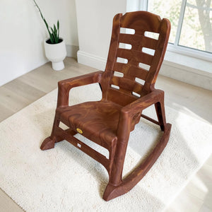 Silla mecedora plástica National acabado Mango, vista frontal lateral, con brazos, respaldo alto y diseño tipo madera.