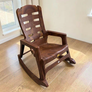 Silla mecedora plástica National acabado Mango en vista lateral frontal, mostrando asiento amplio, brazos y respaldo alto.