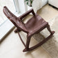 Vista superior lateral de silla mecedora plástica National acabado Sándalo, con asiento ergonómico, brazos integrados y base de balanceo.